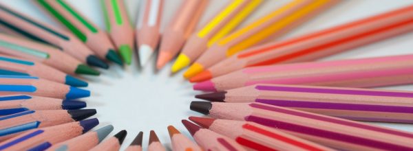 Colourful pencils all pointing towards the centre of a circle