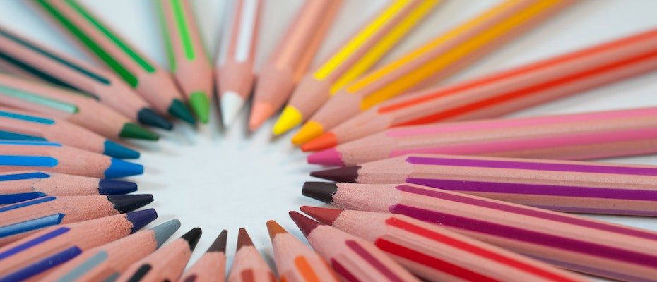 Colourful pencils all pointing towards the centre of a circle
