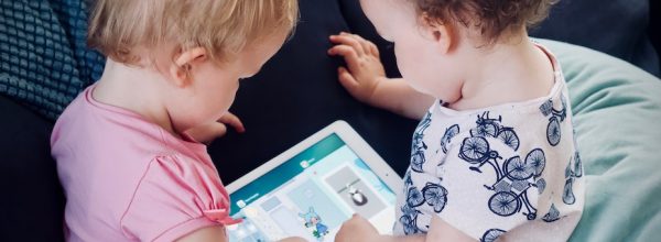 Two young children looking at an iPad together