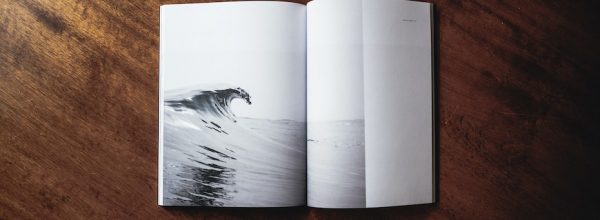 Open book with the image of a cresting wave